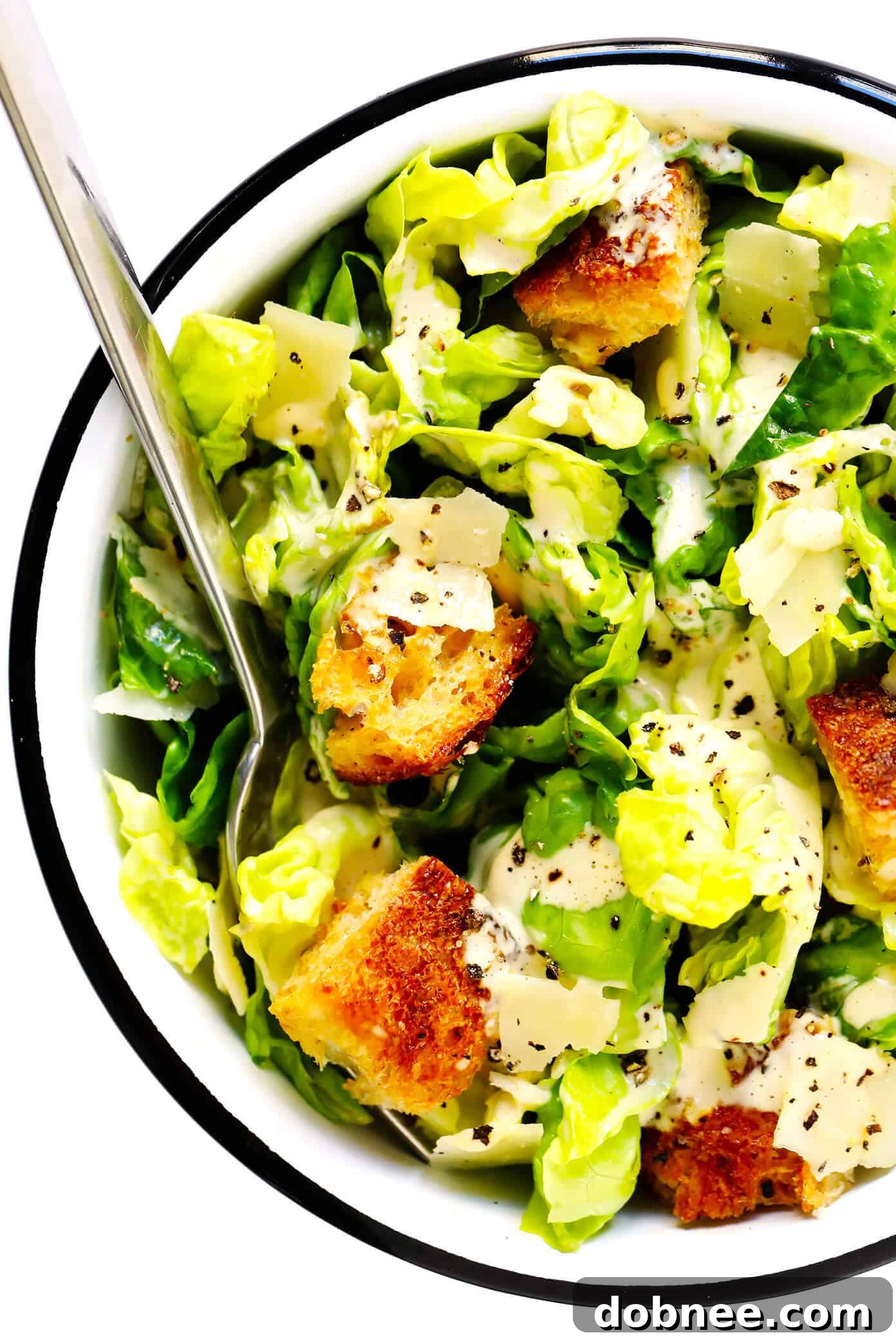 A bowl of delicious Caesar salad, garnished with extra croutons and Parmesan, ready to be enjoyed.