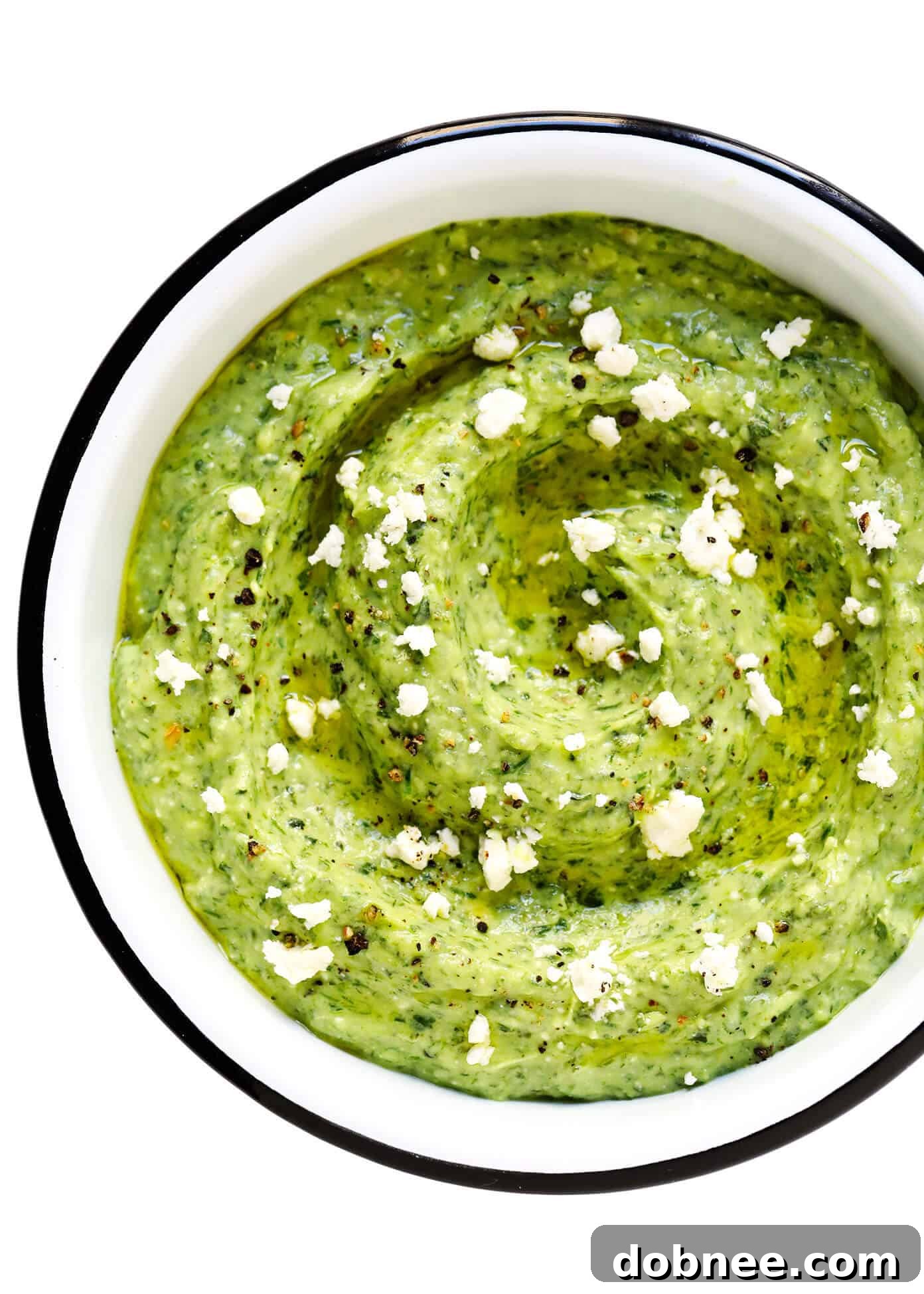 Close-up of Green Goddess Feta Dip in a bowl, garnished with crumbled feta