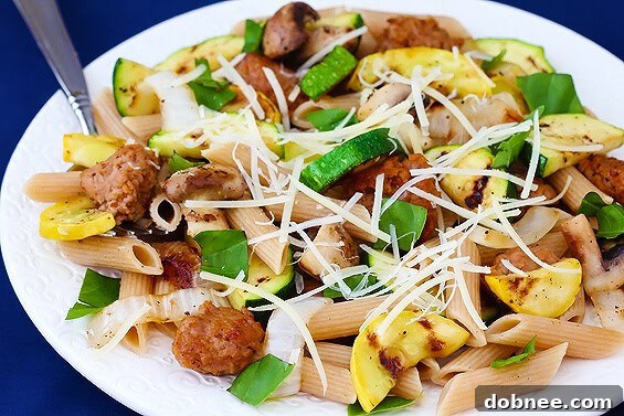 Close-up shot of cooked Sausage and Zucchini Pasta in a skillet.