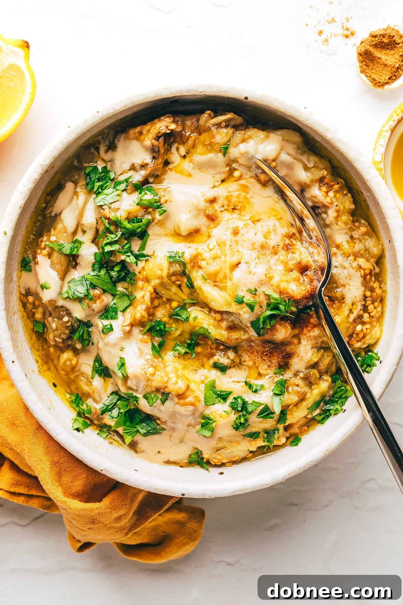 Delicious creamy baba ganoush in a bowl, garnished with fresh parsley and a drizzle of olive oil.