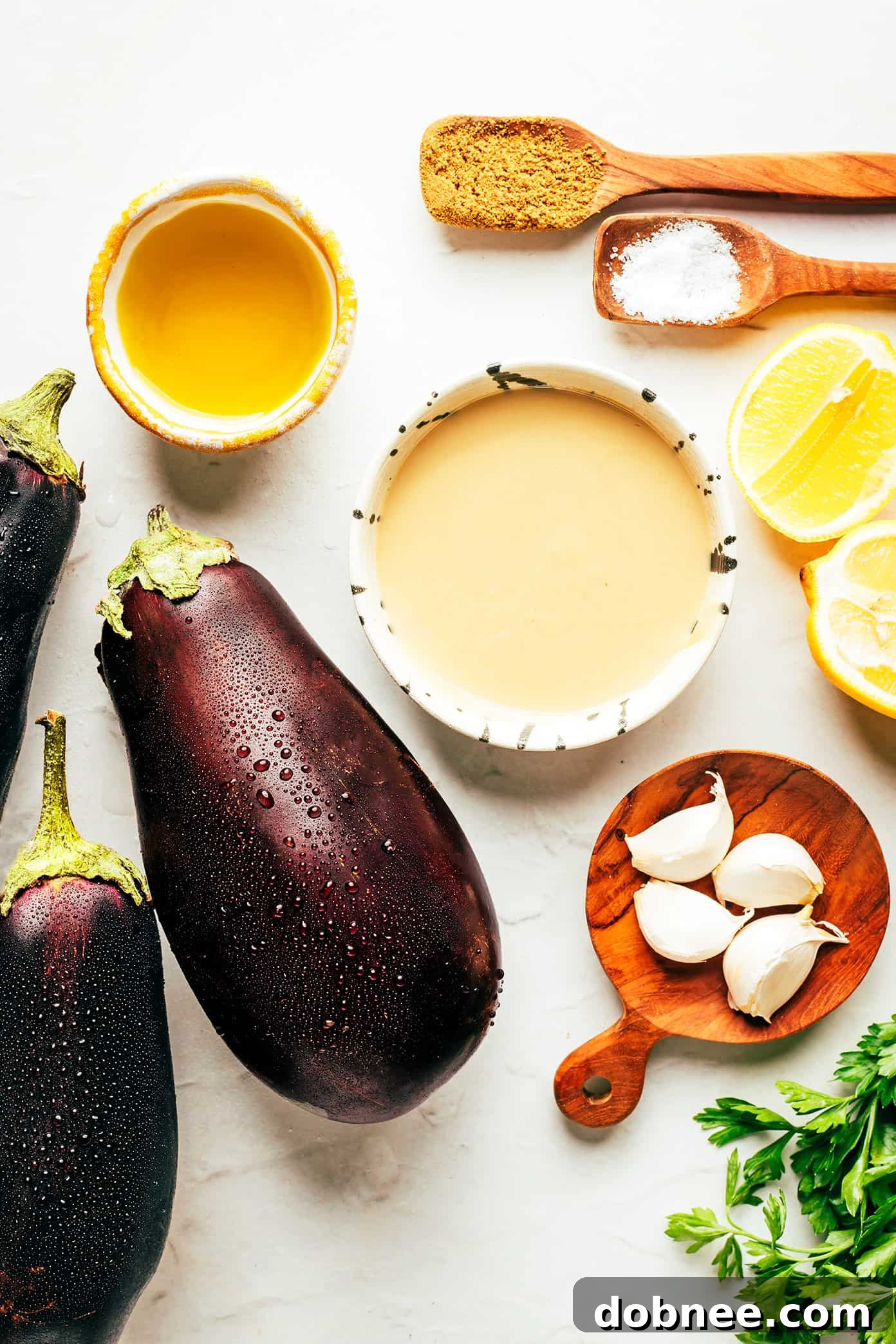 Fresh eggplants and garlic cloves, ready for roasting to make baba ganoush.