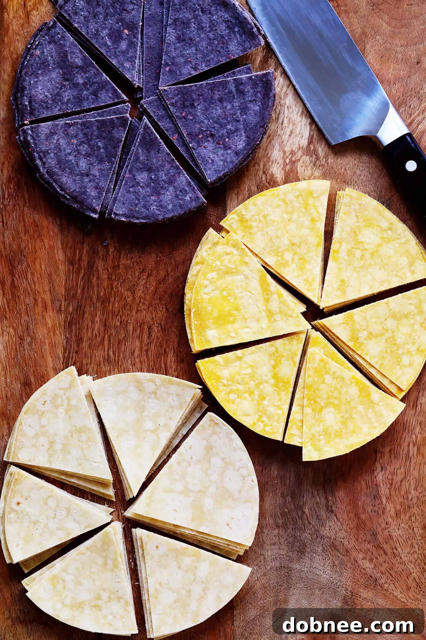 Variety of corn tortillas in blue, yellow, and white colors, ready to be cut and fried.