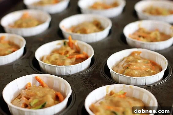 Golden Carrot & Zucchini Muffins Ready to Enjoy Freshly baked carrot zucchini muffins cooling on a wire rack, showcasing their golden-brown tops and moist interior.