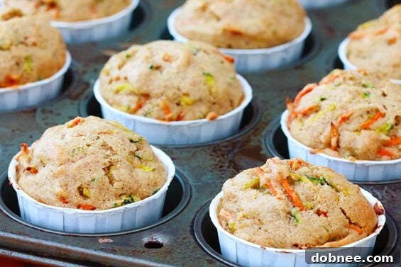 Moist & Flavorful Carrot Zucchini Muffins - Perfect Every Time A stack of golden brown carrot and zucchini muffins, highlighting their fluffy texture and delicious appeal.