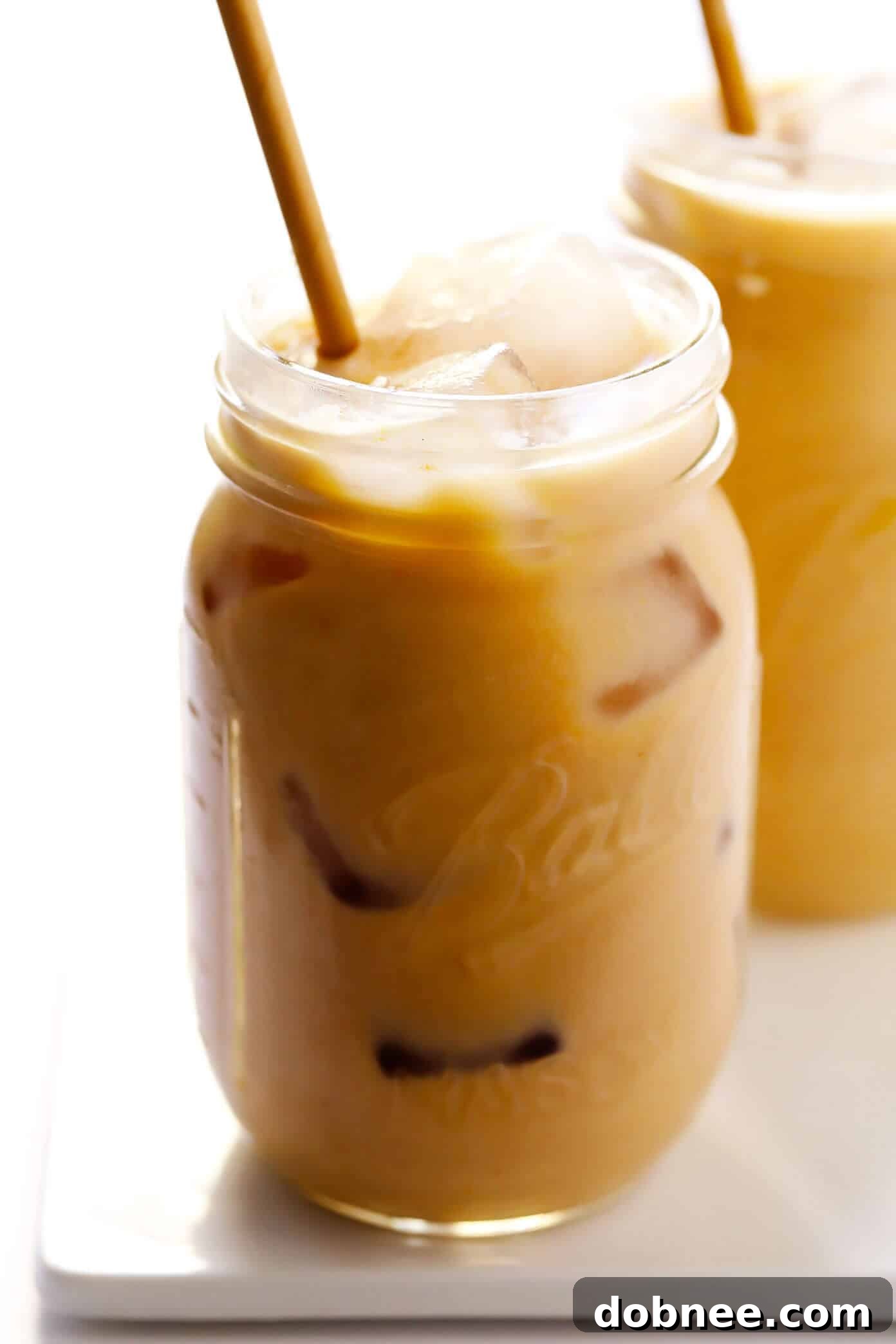 Two Iced Pumpkin Spice Lattes without whipped cream, ready to serve