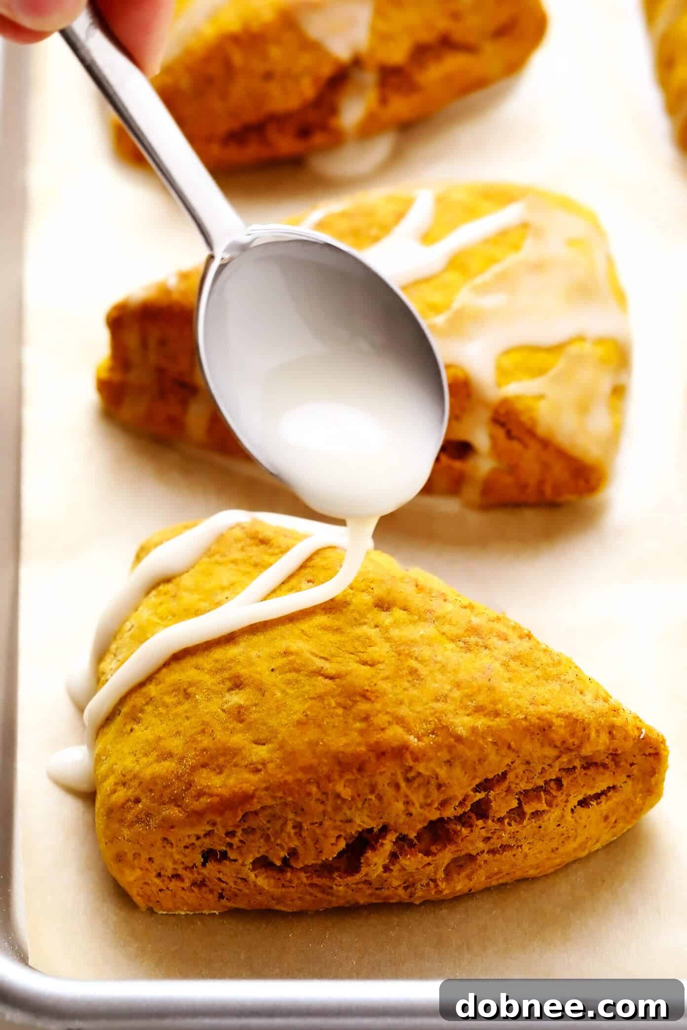 Drizzling light vanilla glaze over freshly baked pumpkin scones