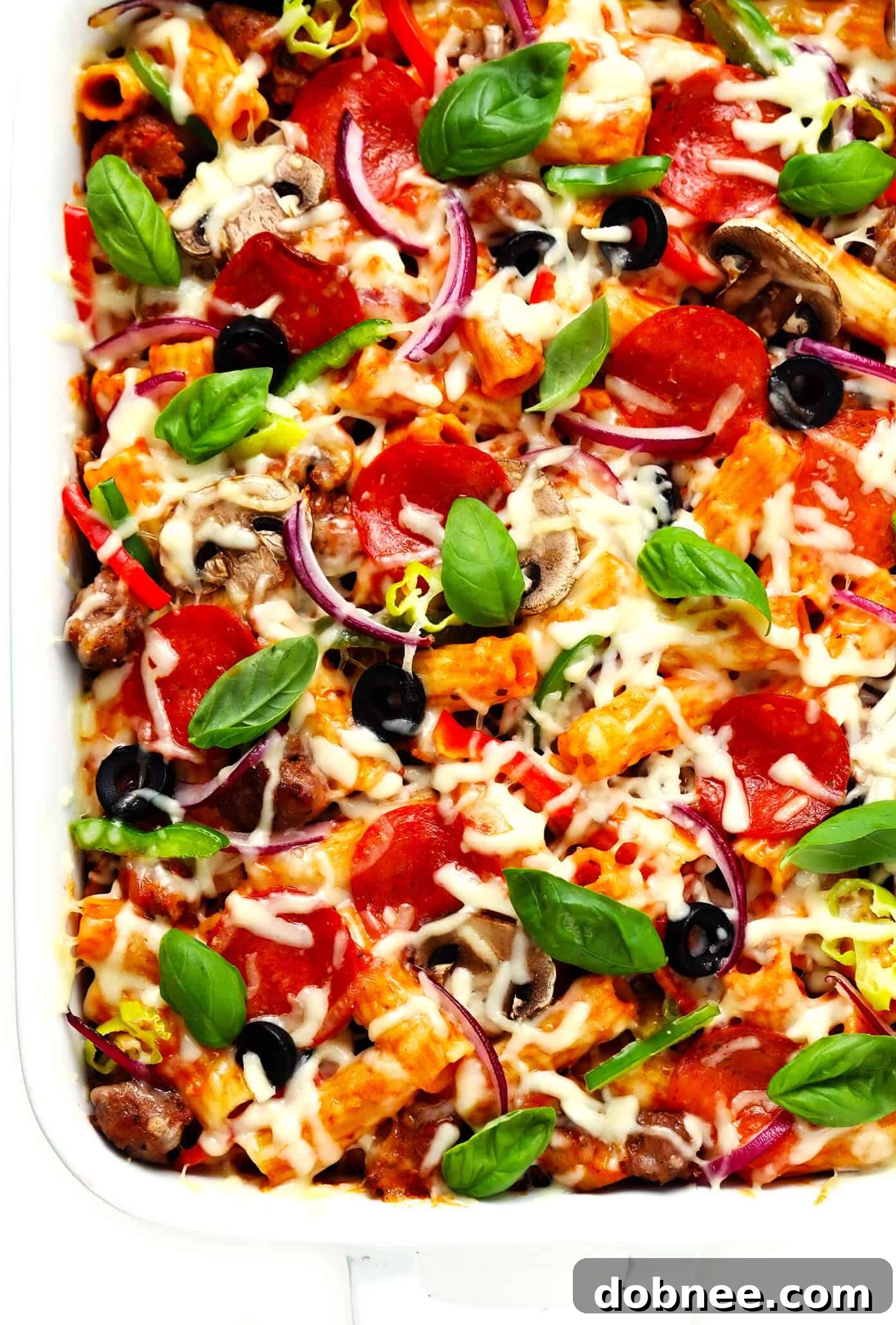 Pizza Baked Ziti in Baking Dish with Basil Garnish