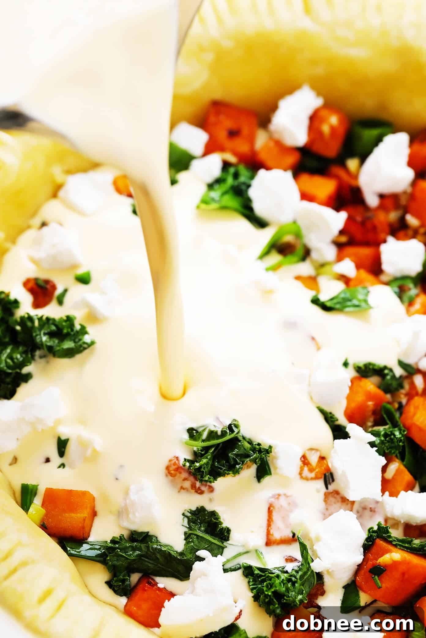 Pouring the eggs into the butternut squash quiche