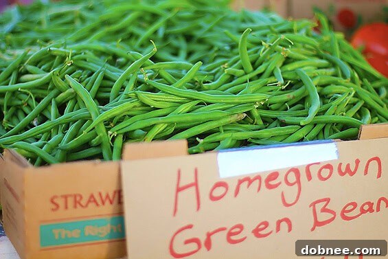 Freshly picked green beans, long and slender, piled high at a market stall
