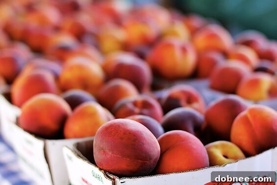 A vibrant display of fresh, ripe peaches at a Kansas City farmers market stall