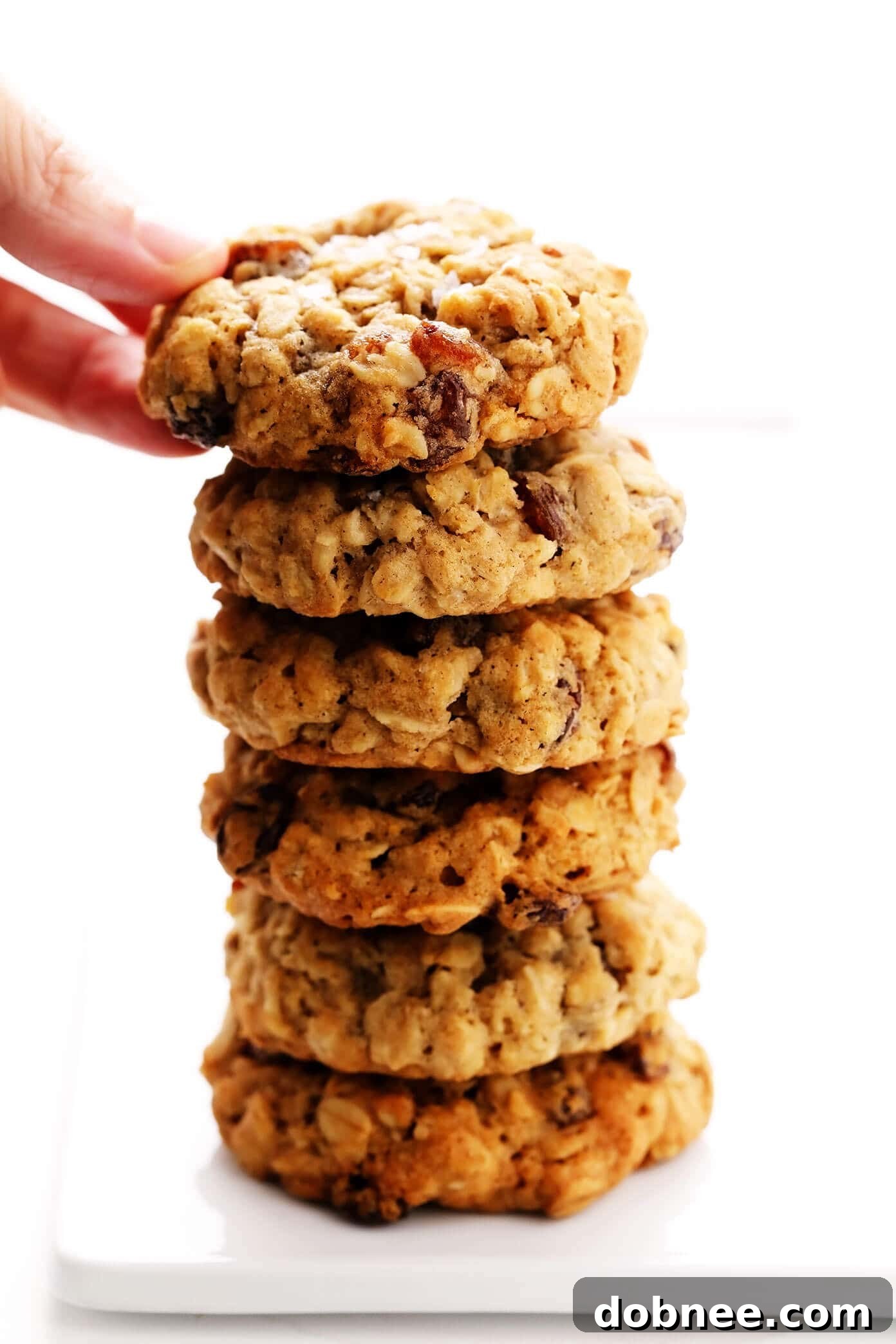 A stack of golden-brown oatmeal raisin cookies, highlighting their soft and chewy texture.