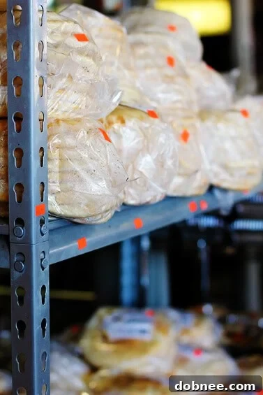 The Irresistible Aroma of Freshly Baked Pita Bread Freshly baked, warm pita bread stacked on a table at a market, inviting customers with its appealing texture.