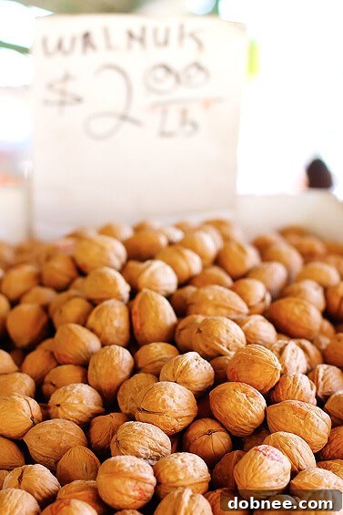 Walnuts: A Blend of Culinary Delight and Childhood Memories A large pile of shelled walnuts in their natural form, ready for purchase at a farmers market stall.