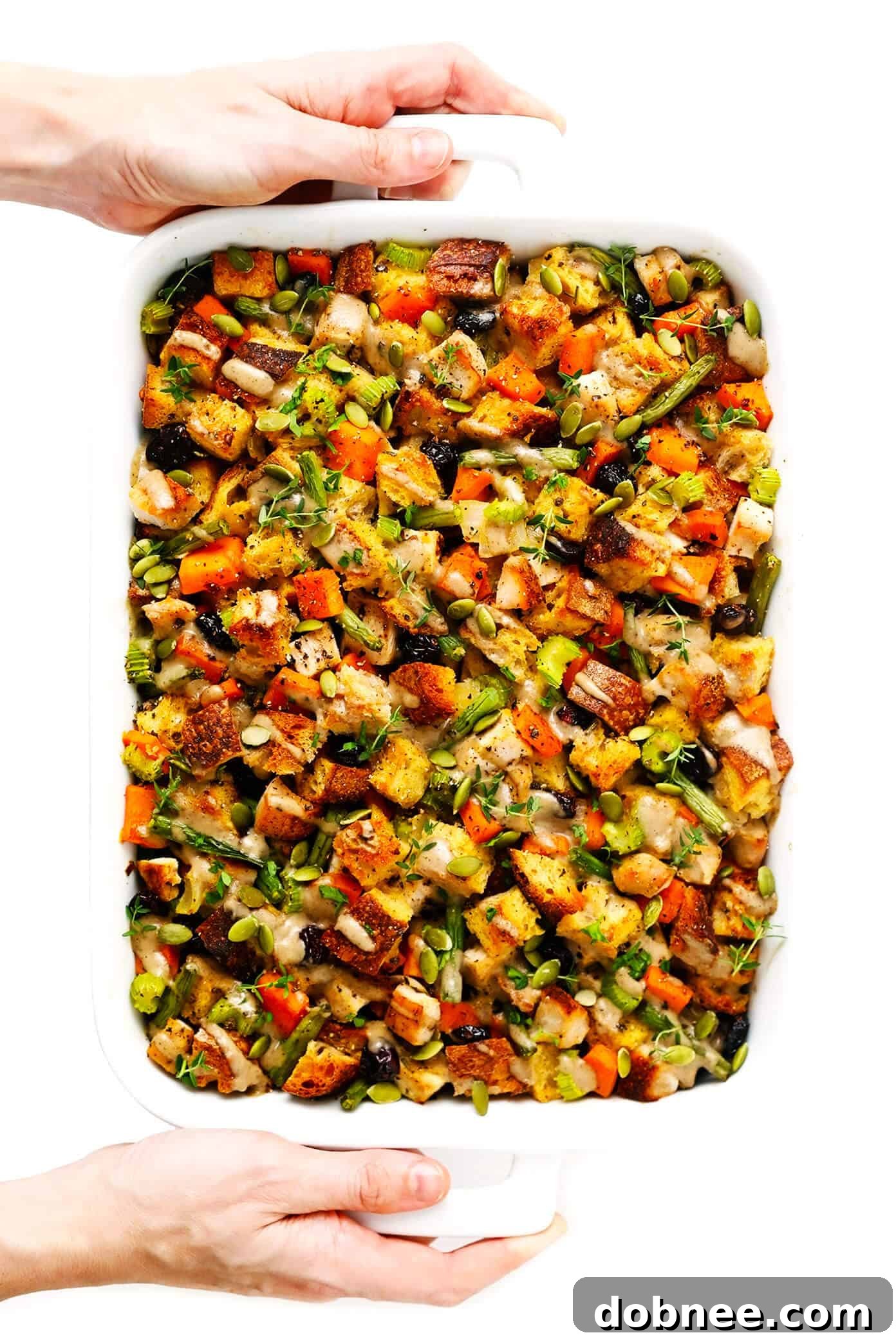 Holding a bowl of Thanksgiving Casserole with Turkey and Sweet Potatoes, showcasing the hearty and delicious contents.