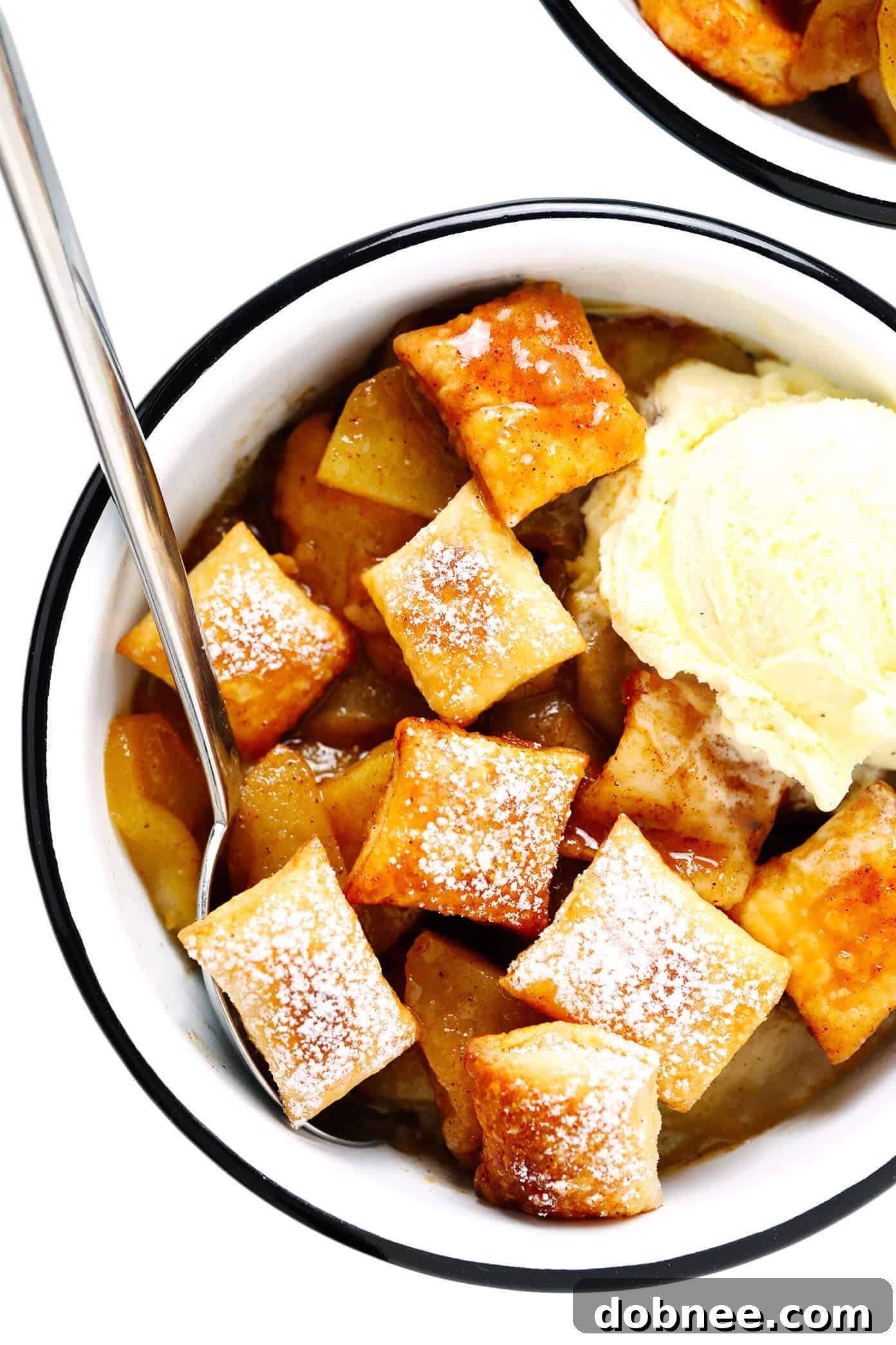 Cozy apple pandowdy served in bowls with vanilla ice cream. Apple Pandowdy served in individual bowls with scoops of vanilla ice cream, a perfect cozy dessert.