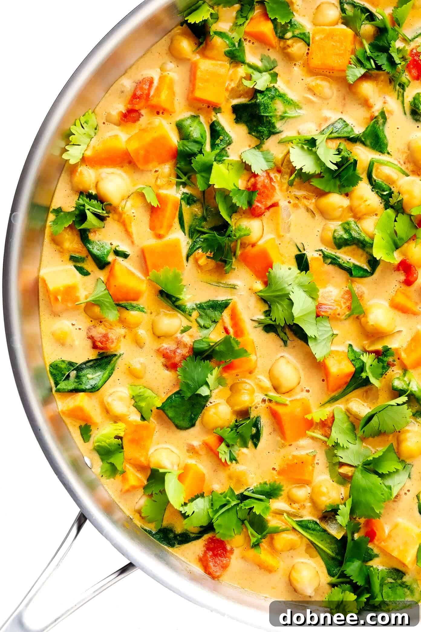 A vibrant bowl of Sweet Potato Chickpea Coconut Curry garnished with fresh cilantro, ready to be enjoyed. This easy, healthy vegan recipe is perfect for weeknight dinners.