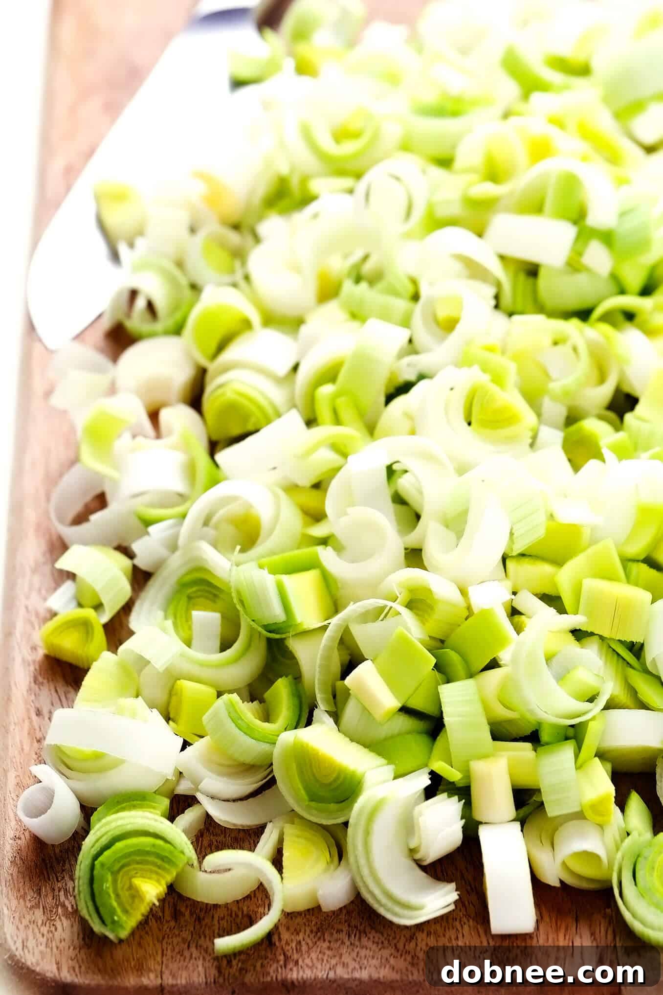 Freshly chopped leeks on a wooden cutting board