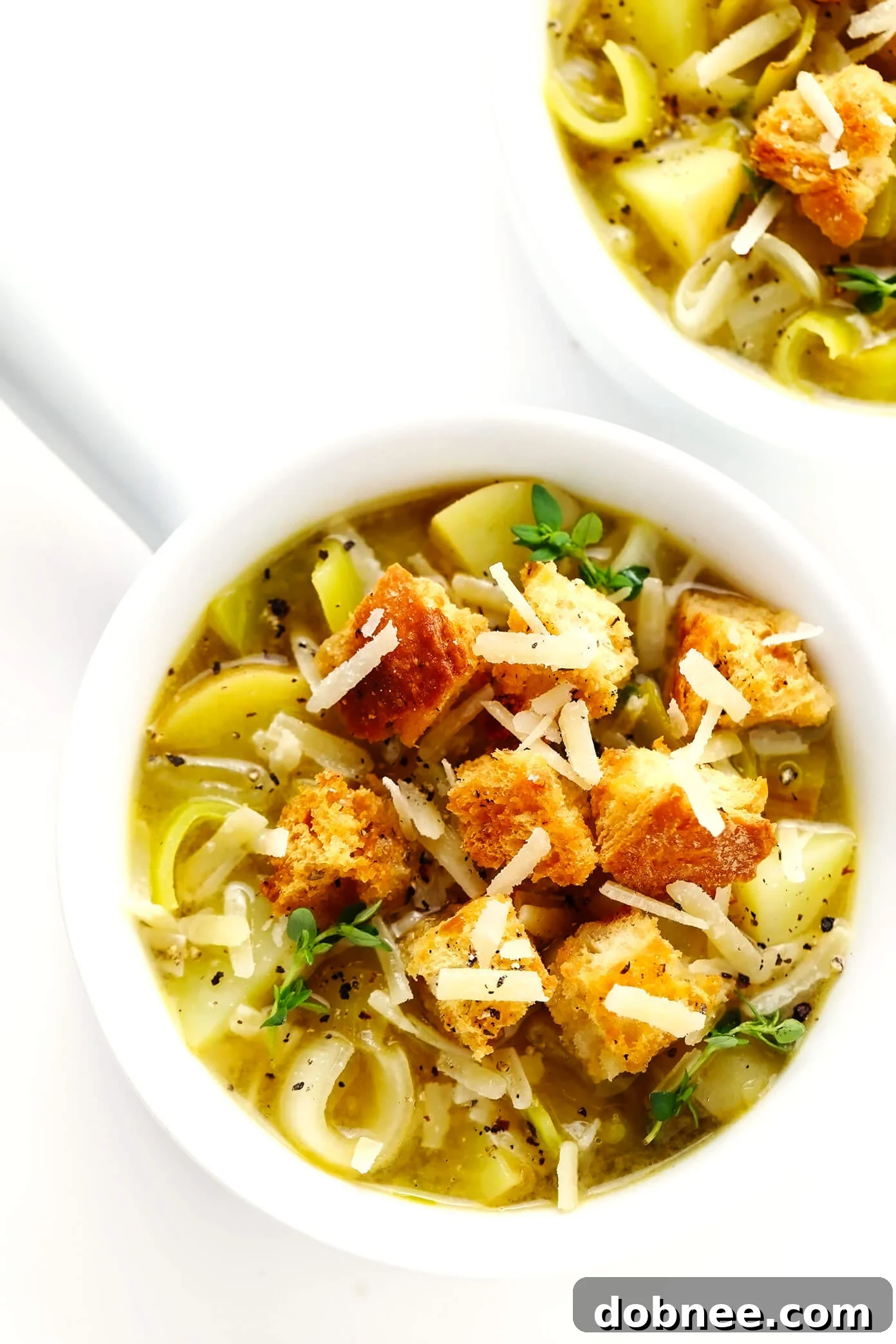 Bowls of Rustic Potato Leek Soup with Homemade Croutons and Parmesan cheese