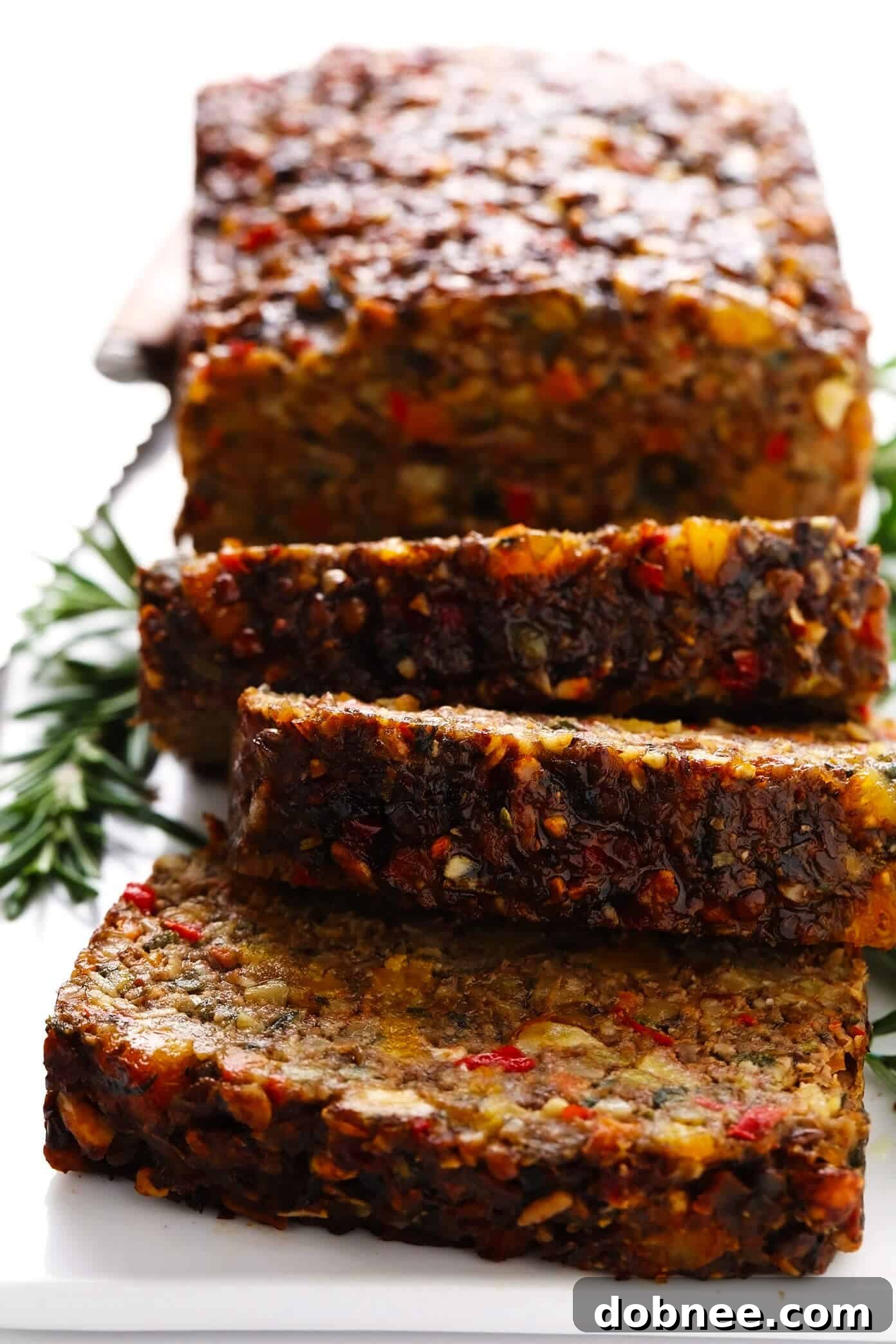 This Nut Roast recipe is packed with a deliciously sweet and savory blend of nuts, veggies, lentils, dried apricots and fresh rosemary and sage. It's easy to prep in advance, naturally gluten-free + vegetarian + vegan, and absolutely delicious served with cranberry sauce and/or gravy. Perfect for the holidays (especially Christmas, Thanksgiving or Easter) or Sunday dinner! | gimmesomeoven.com #nutroast #vegetarian #vegan #glutenfree #healthy #dinner #christmas #holiday Sliced Nut Roast with a Perfect Texture and Golden Crust