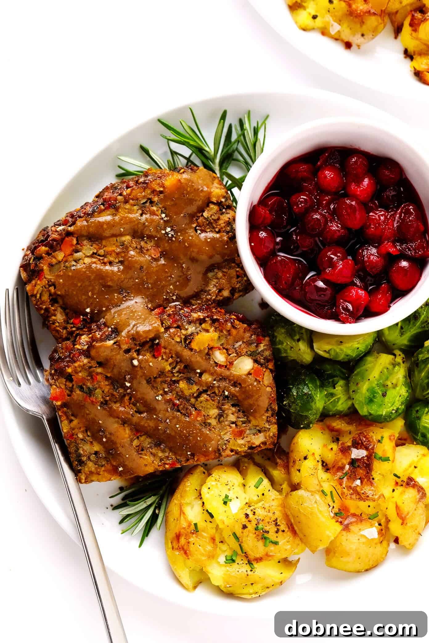 This Nut Roast recipe is packed with a deliciously sweet and savory blend of nuts, veggies, lentils, dried apricots and fresh rosemary and sage. It's easy to prep in advance, naturally gluten-free + vegetarian + vegan, and absolutely delicious served with cranberry sauce and/or gravy. Perfect for the holidays (especially Christmas, Thanksgiving or Easter) or Sunday dinner! | gimmesomeoven.com #nutroast #vegetarian #vegan #glutenfree #healthy #dinner #christmas #holiday Complete Nut Roast Meal with Gravy, Smashed Potatoes, Roasted Brussels Sprouts and Cranberry Sauce