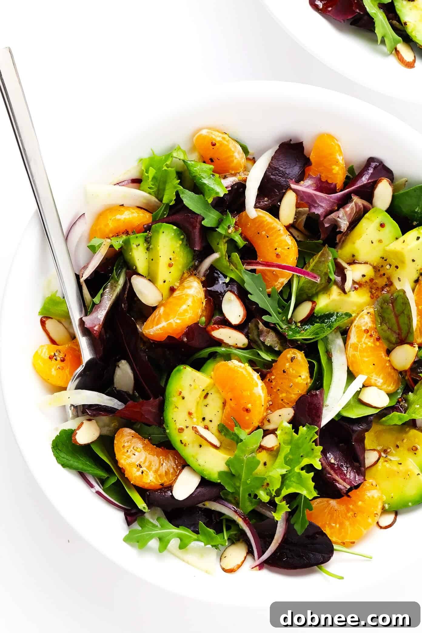 Orange, Fennel and Avocado Salad presented in a beautiful serving bowl, garnished with fresh mint and toasted almonds.