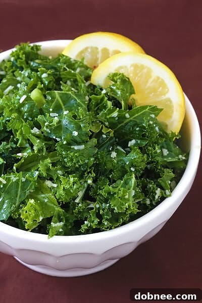 Close-up of a serving of Lemon Parmesan Kale Salad, showcasing the finely chopped kale, grated Parmesan, and a glistening lemon dressing. Fresh and inviting.