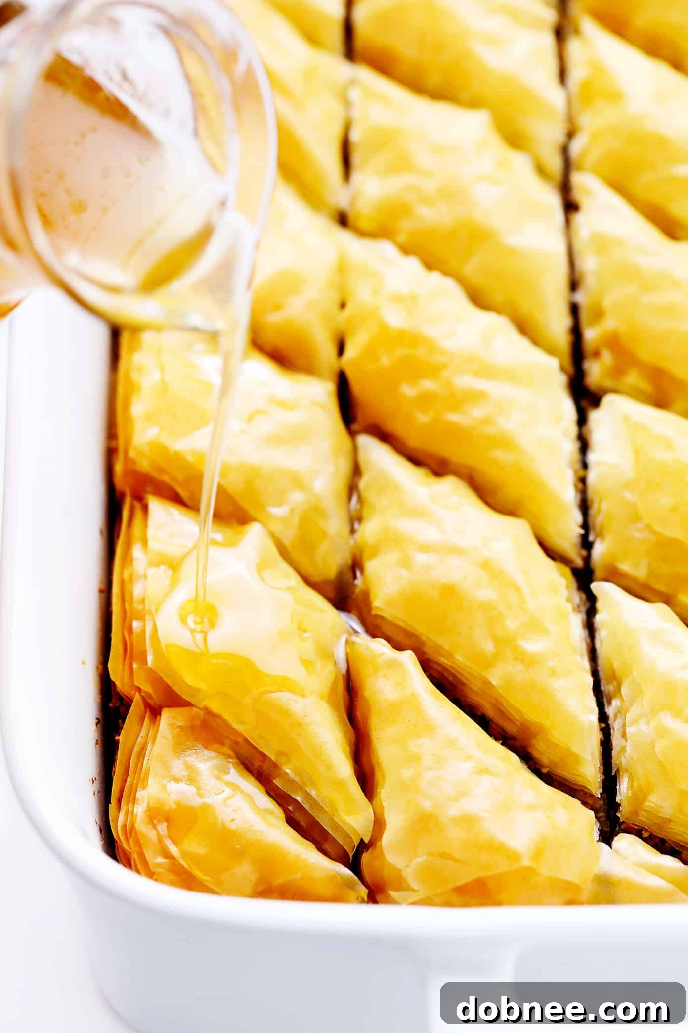 Drizzling cold syrup on hot baklava to create crispy layers