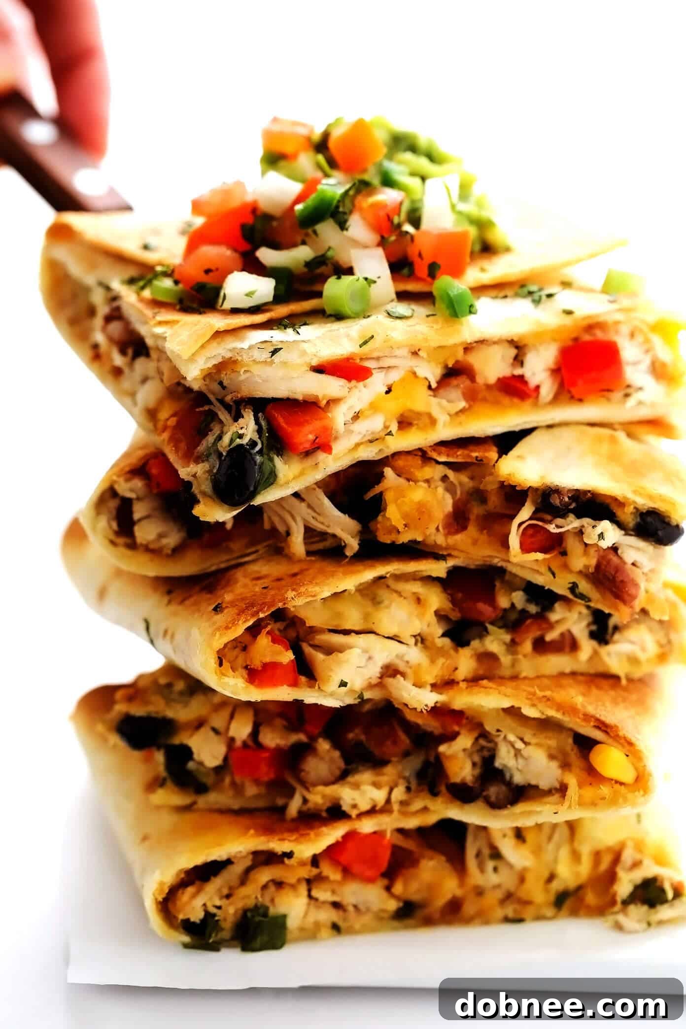Multiple slices of Chicken Sheet Pan Quesadilla stacked, showing the rich filling and golden tortillas.