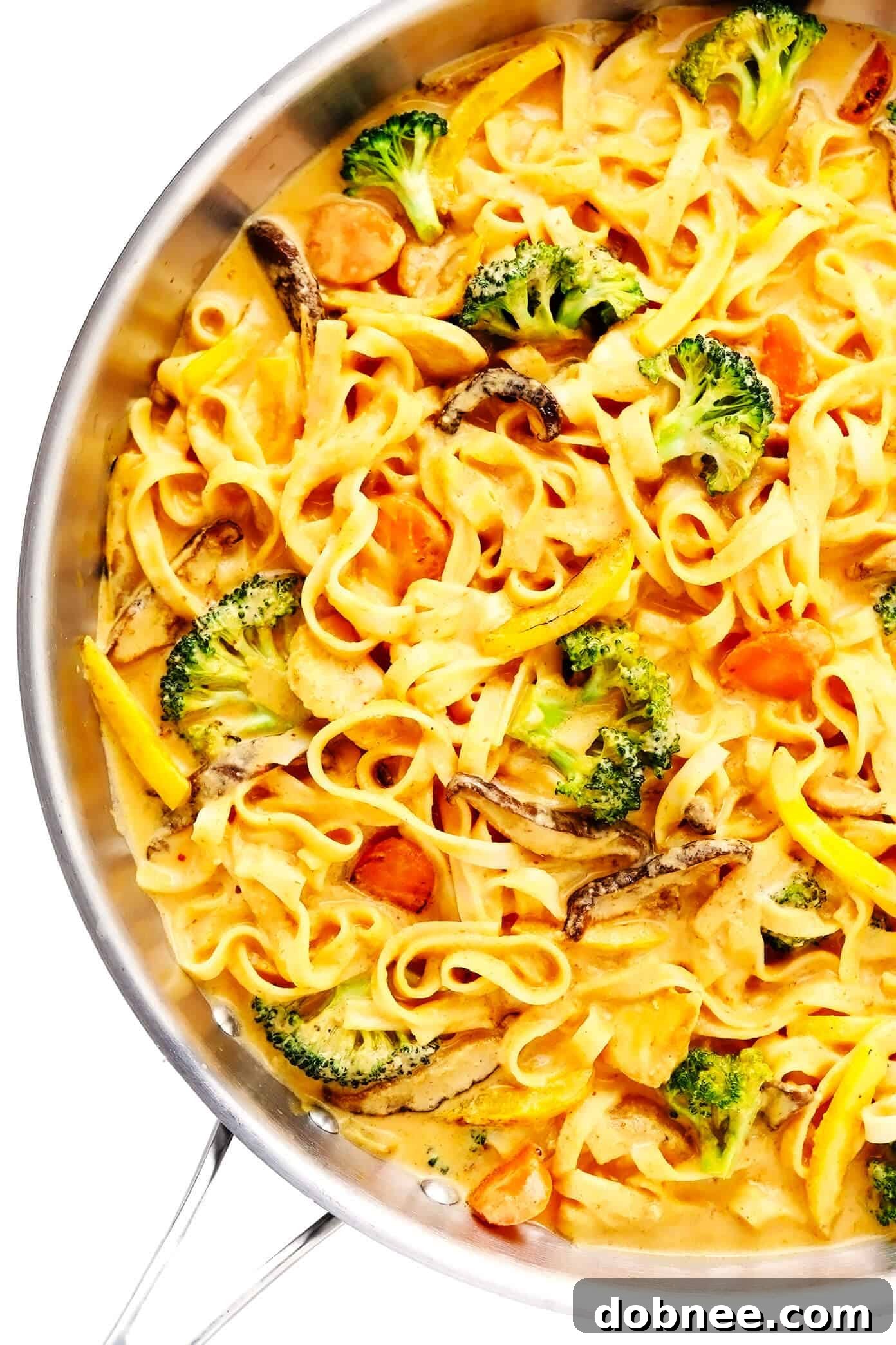 A vibrant bowl of Saucy Thai Curried Peanut Noodles, rich with creamy coconut curry peanut sauce, fresh vegetables, and tender chicken pieces, garnished with cilantro and lime wedges.