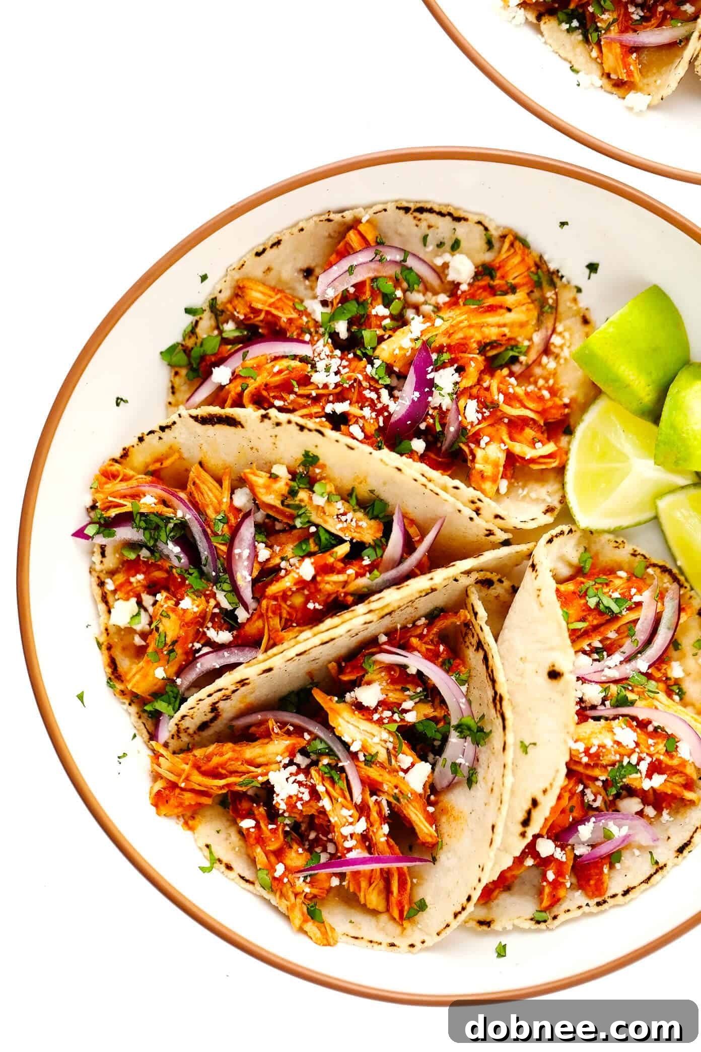 Chicken Tinga Tacos served in bowls with lime wedges and toppings