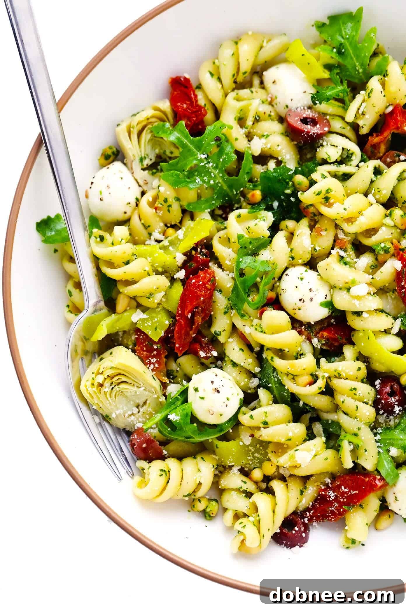 A large bowl of delicious Pesto Pasta Salad, perfect for sharing at any summer gathering. Pesto Pasta Salad in a large bowl, ready to be served at a party or picnic.