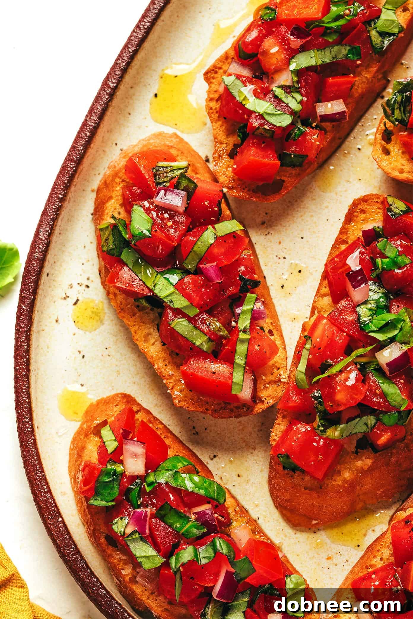 Assortment of finished tomato basil bruschetta on a serving platter, ready to eat