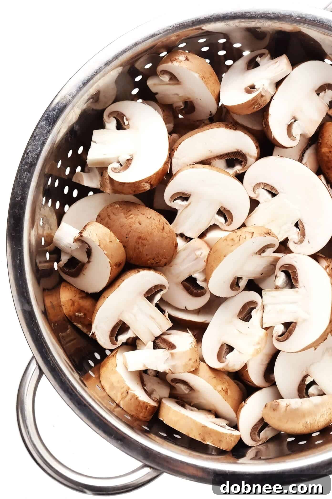 Freshly sliced baby bella (cremini) mushrooms, ready for sautéing, a key ingredient for the creamy tuna pasta.