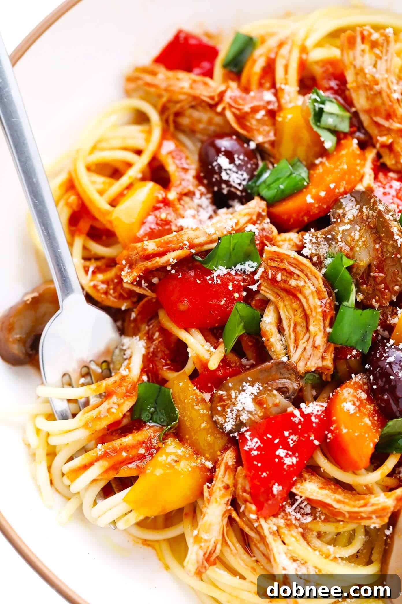 Hearty bowl of Chicken Cacciatore with spaghetti and fresh basil