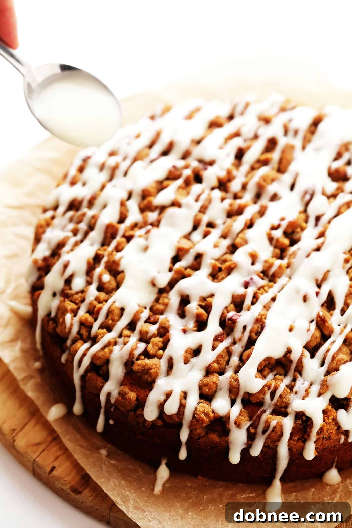 Drizzling cream cheese icing on pumpkin crumb cake