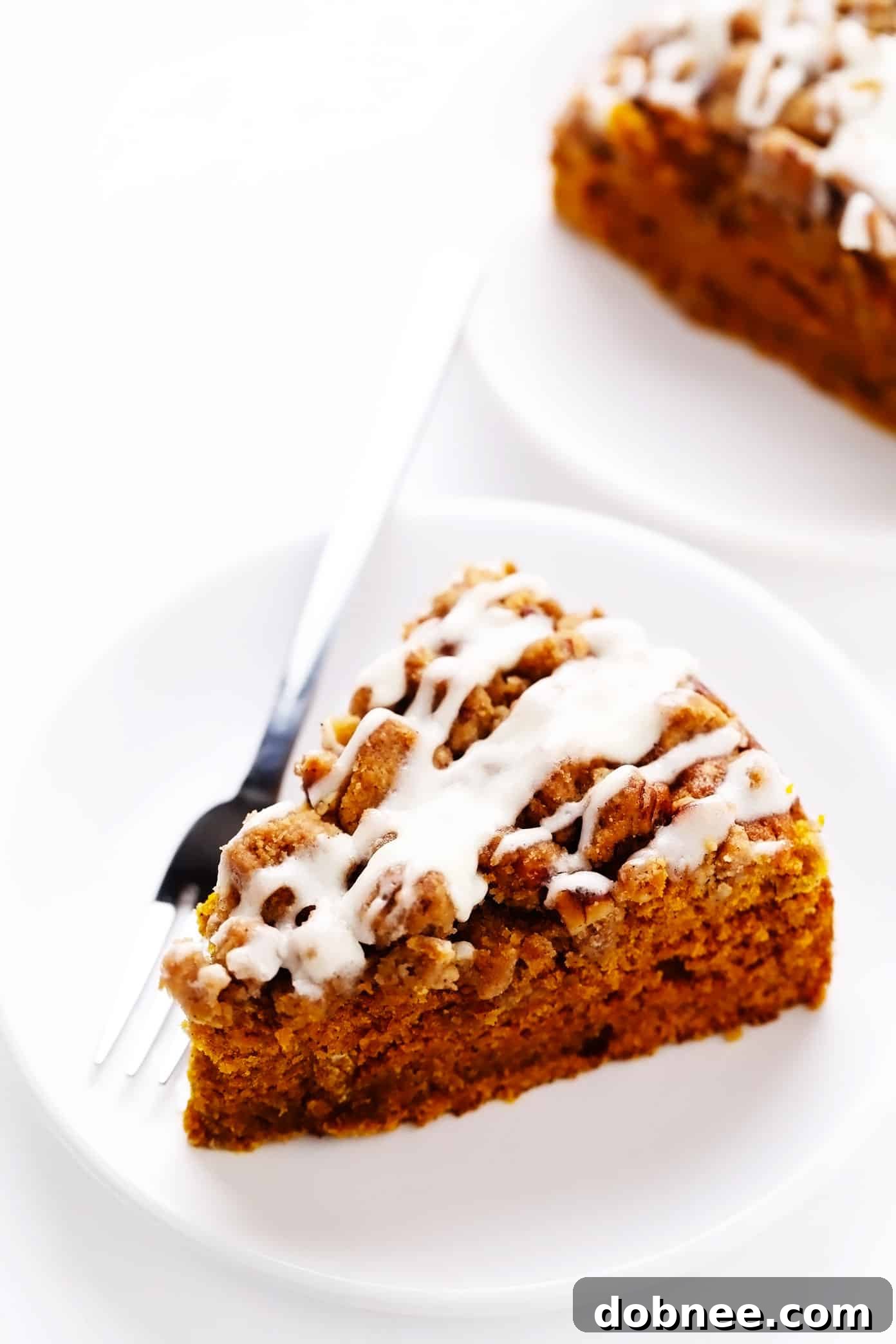 Serving pieces of pumpkin coffee cake with streusel and cream cheese icing