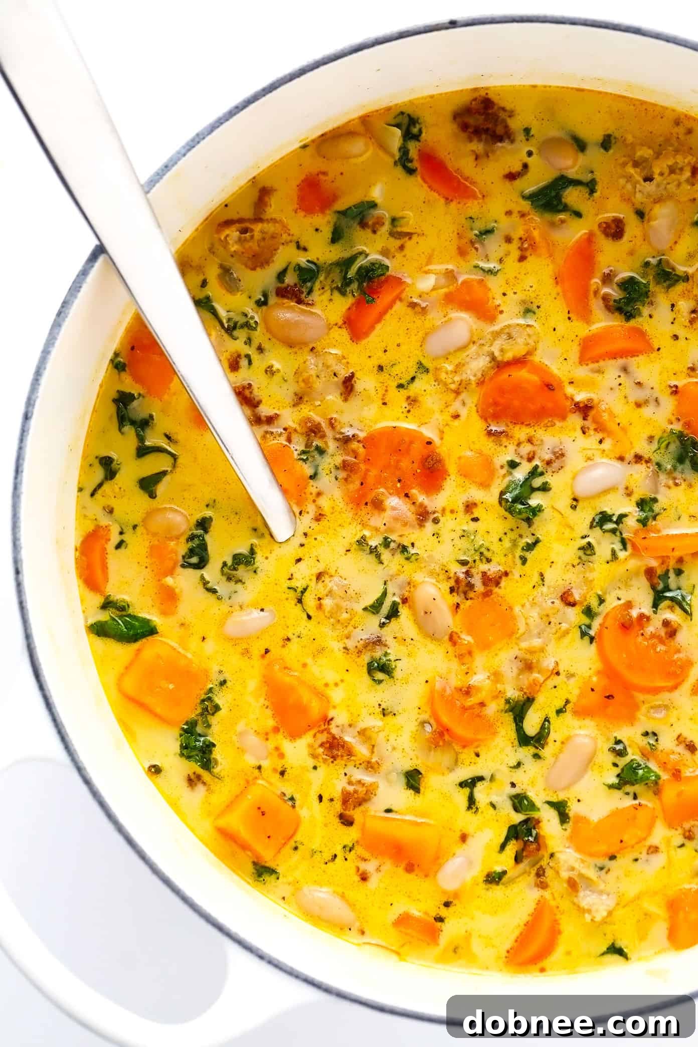 Creamy Sweet Potato and Sausage Soup simmering in a stockpot, a perfect cozy dinner.