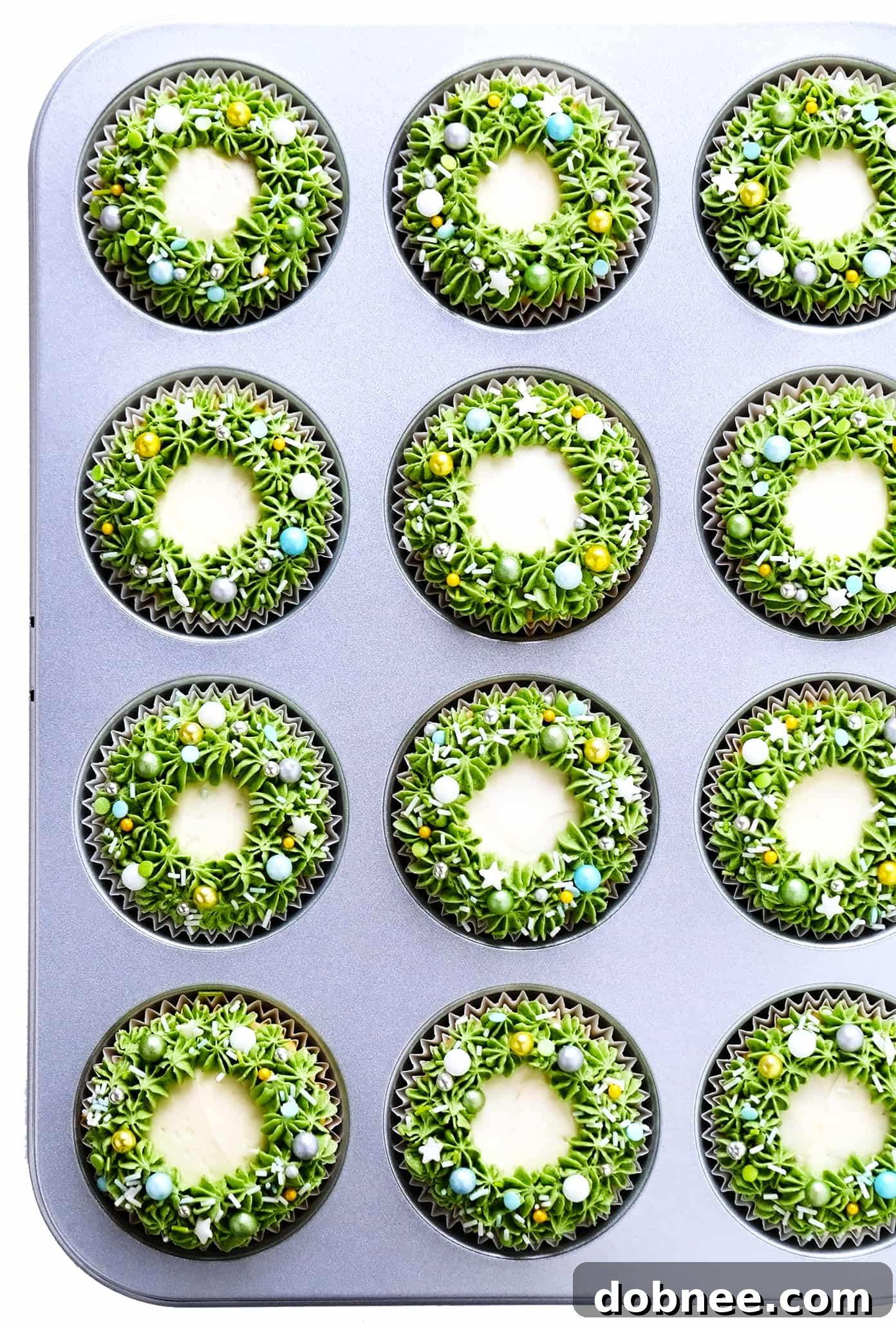 Delicate Christmas Wreath Cupcakes adorned with green frosting and colorful sprinkles, perfect for holiday gatherings.