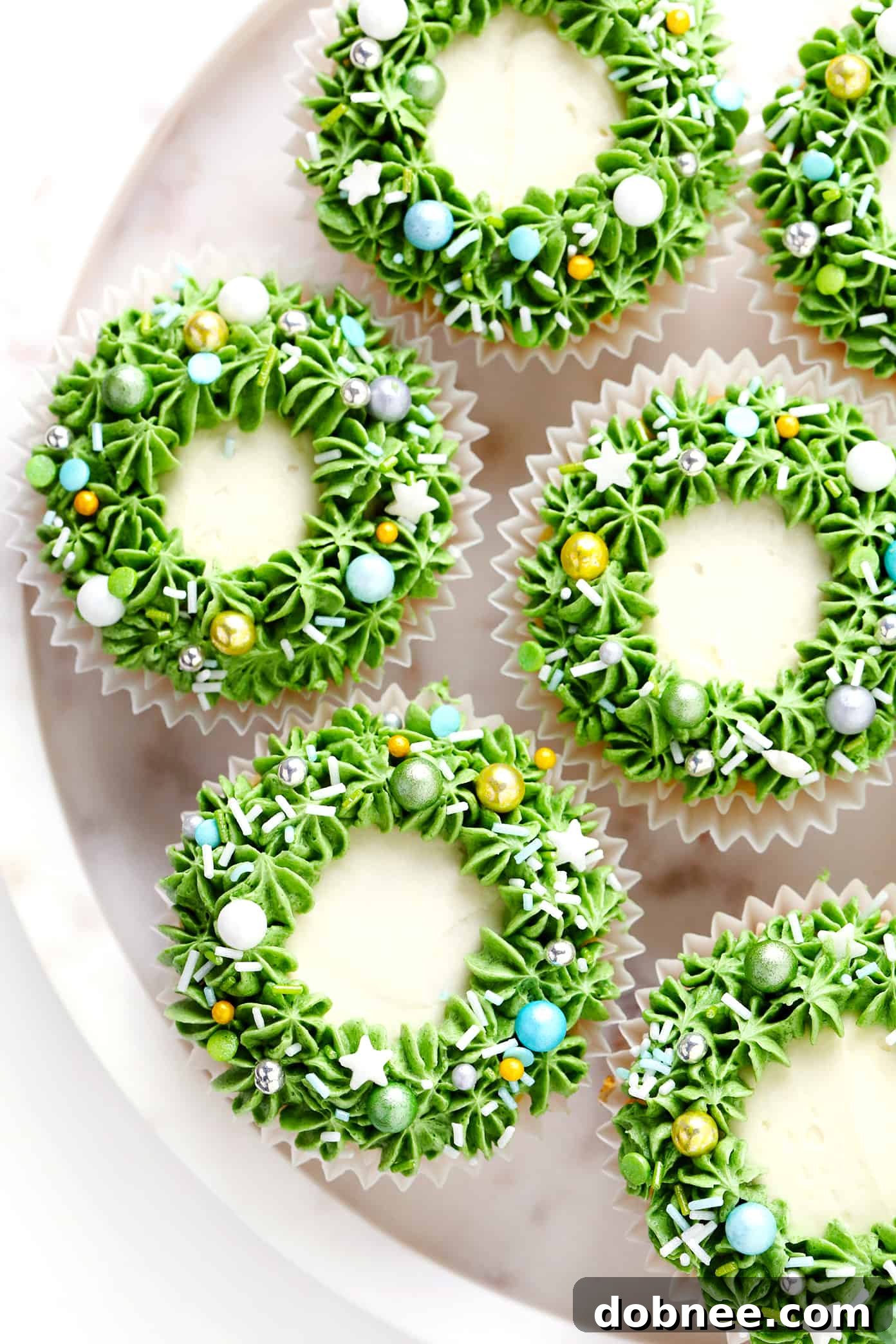 Close-up of a festive Christmas Wreath Cupcake with vibrant green frosting and colorful sprinkles.