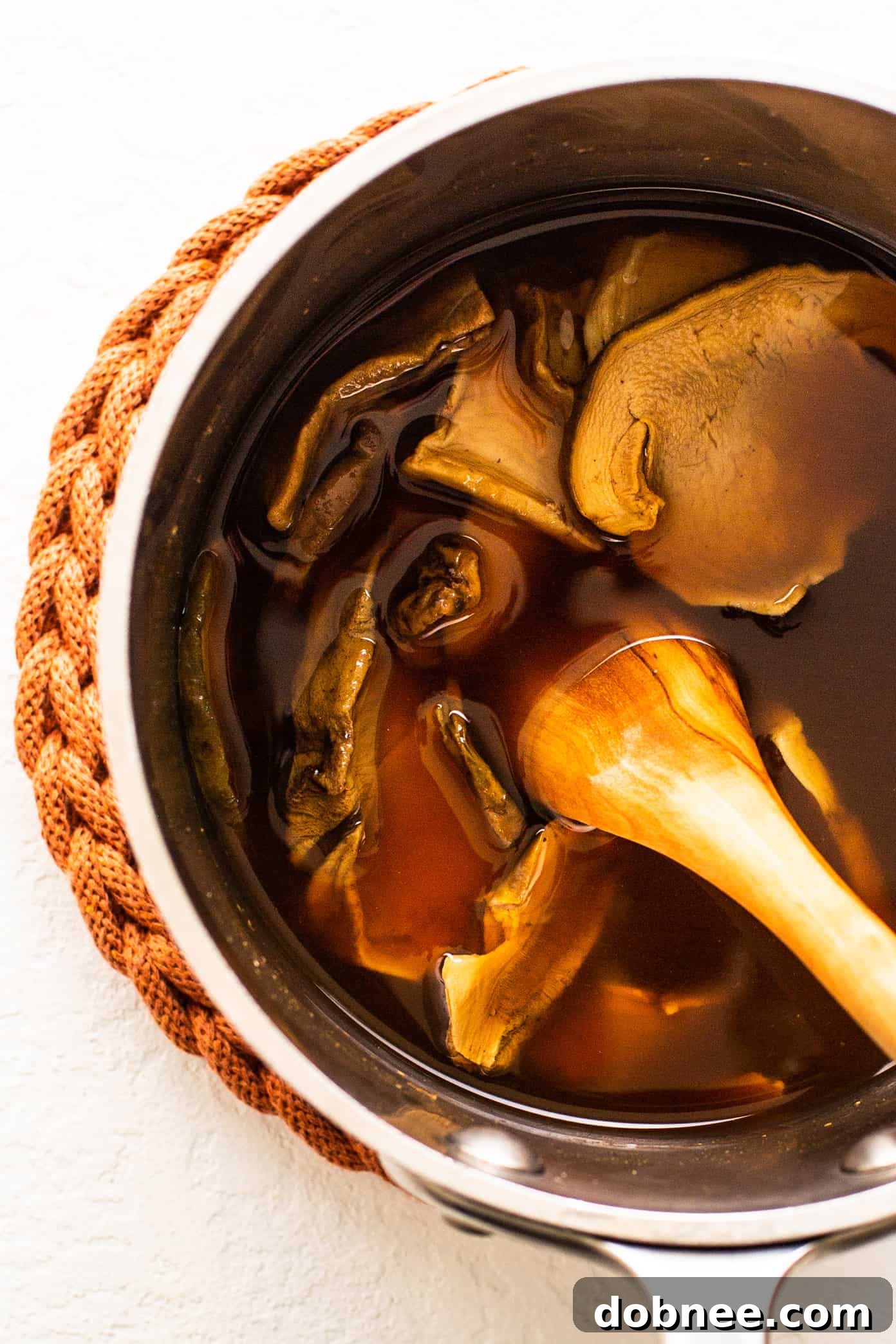 Dried Porcini Mushrooms Being Reconstituted in Hot Broth for Pasta alla Boscaiola