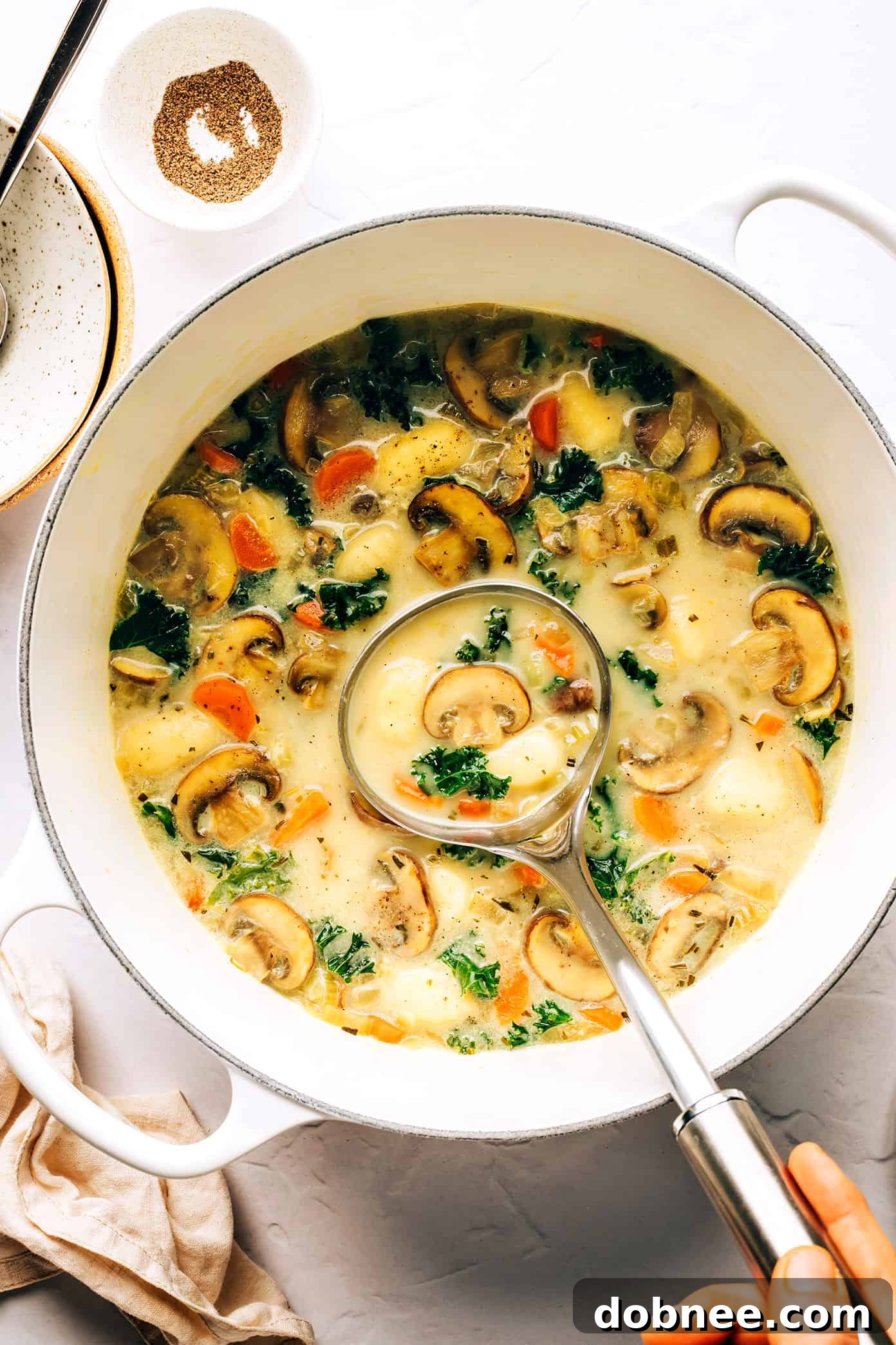 Gnocchi, Mushroom and Kale Soup simmering in a large pot, showcasing its rich, creamy texture and vibrant ingredients.