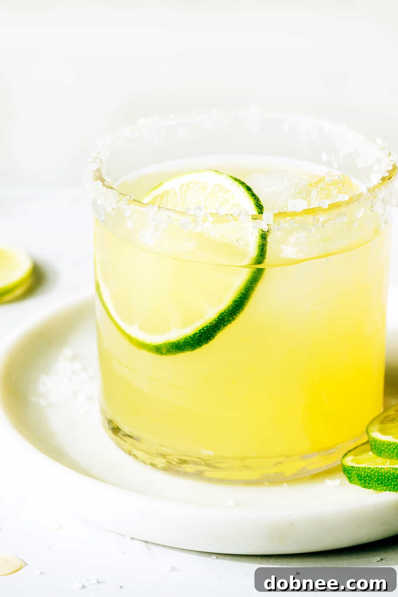 A vibrant Bourbon Margarita with a salt rim, garnished with a lime slice, ready to be enjoyed.
