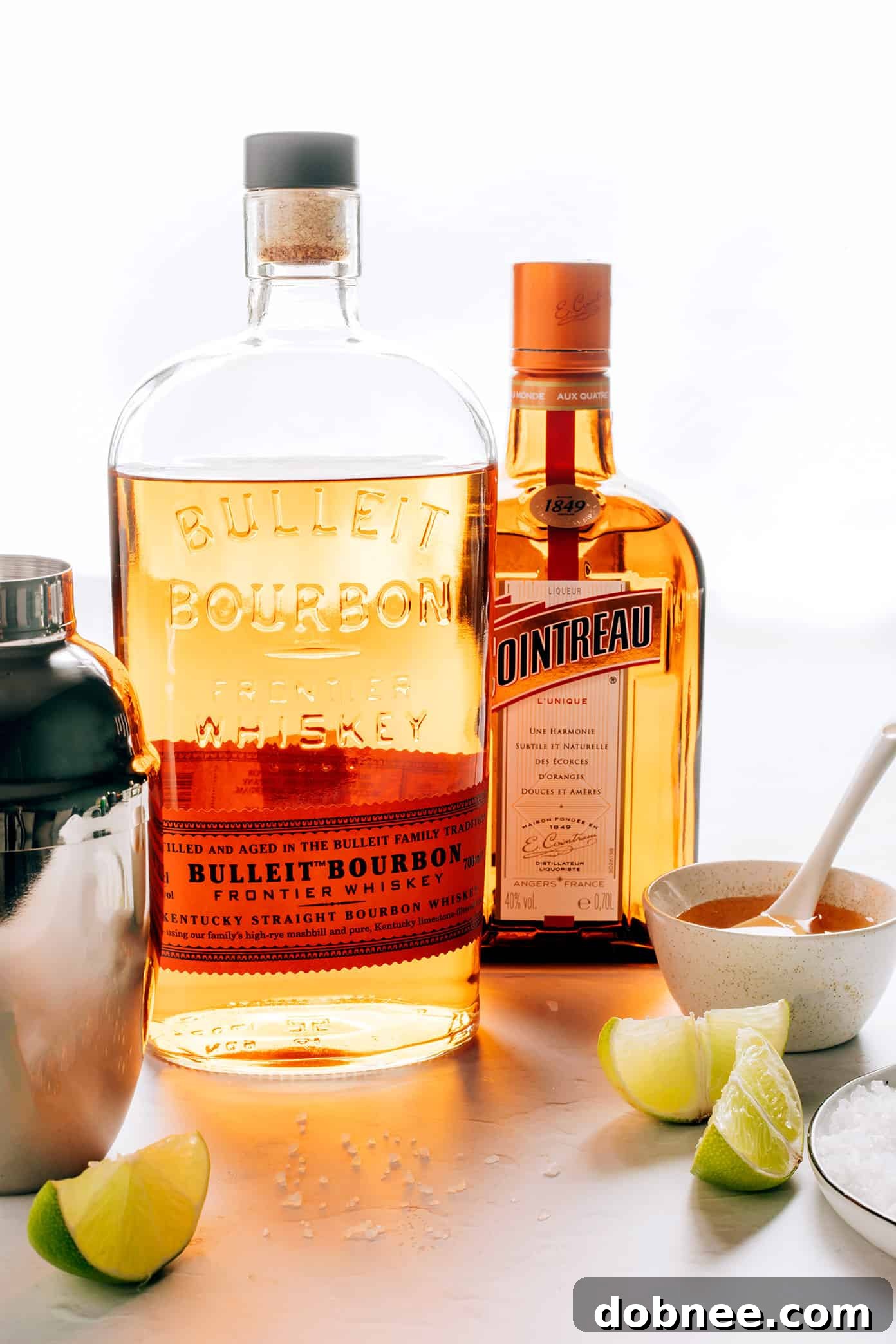 Close-up of a freshly made Bourbon Margarita in a glass with ice and a lime garnish.