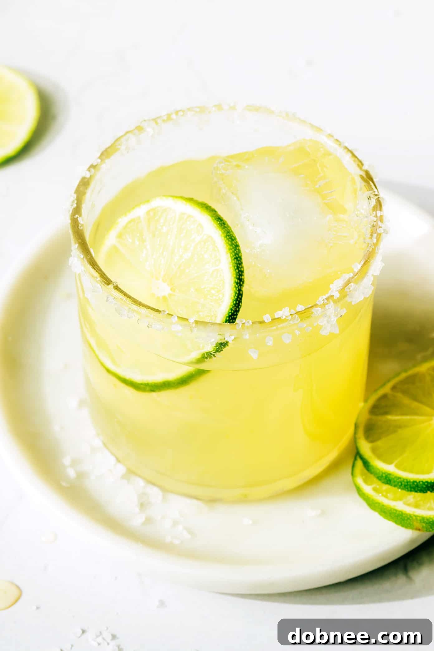 A perfectly crafted Bourbon Margarita with a salt rim, served on a round coaster, emphasizing its inviting amber hue.