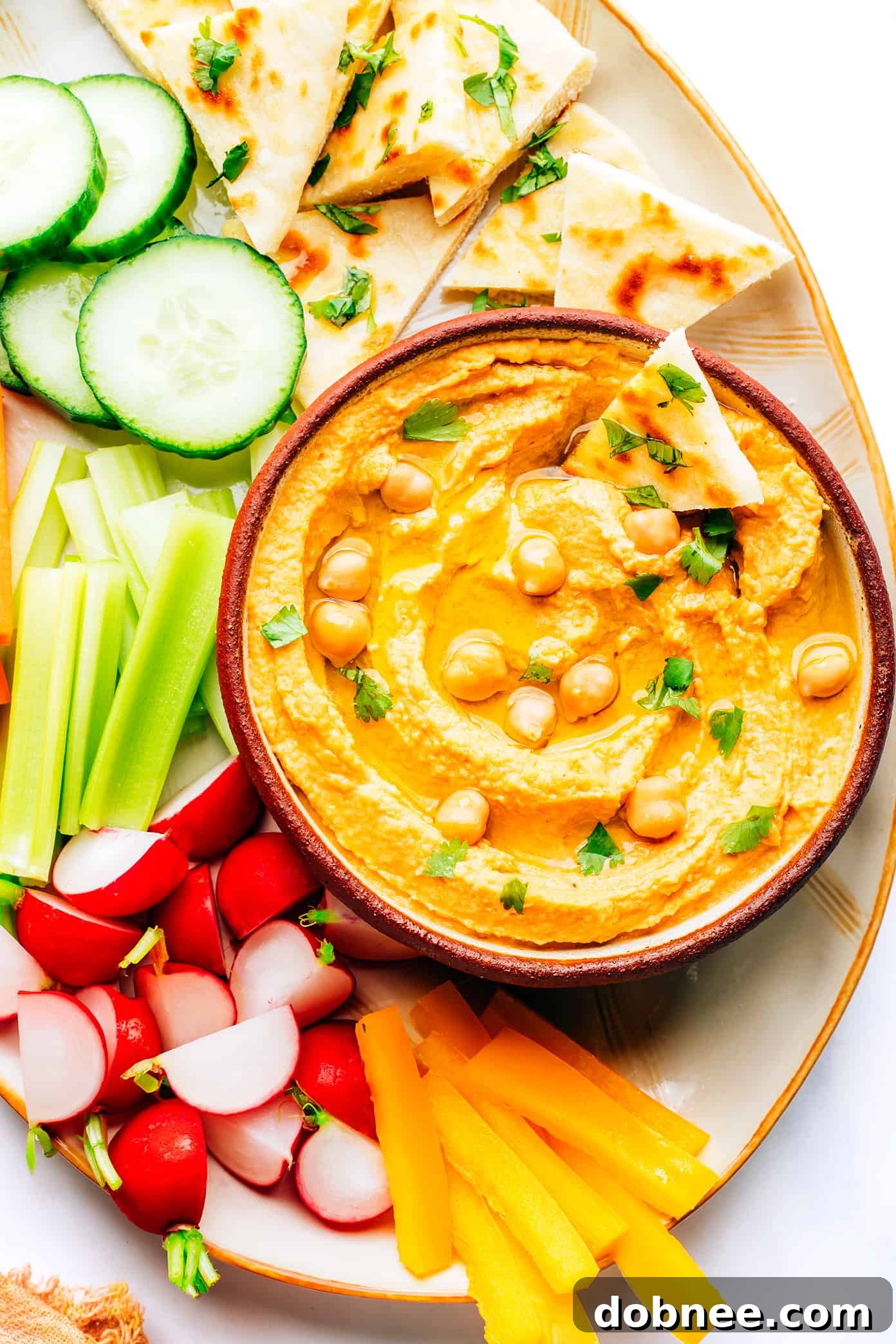 Delicious Red Curry Hummus in a serving bowl with fresh cilantro