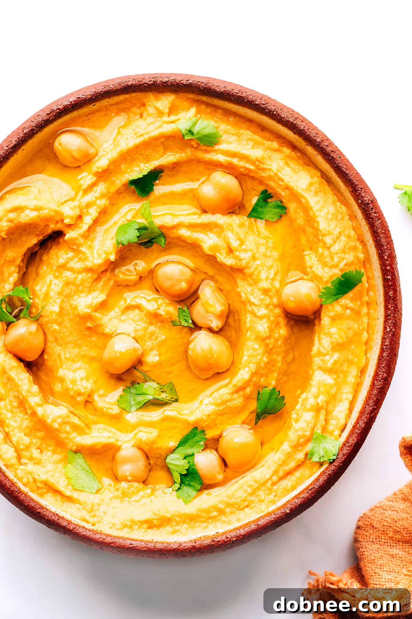Thai Red Curry Hummus in a bowl, garnished with chickpeas and cilantro