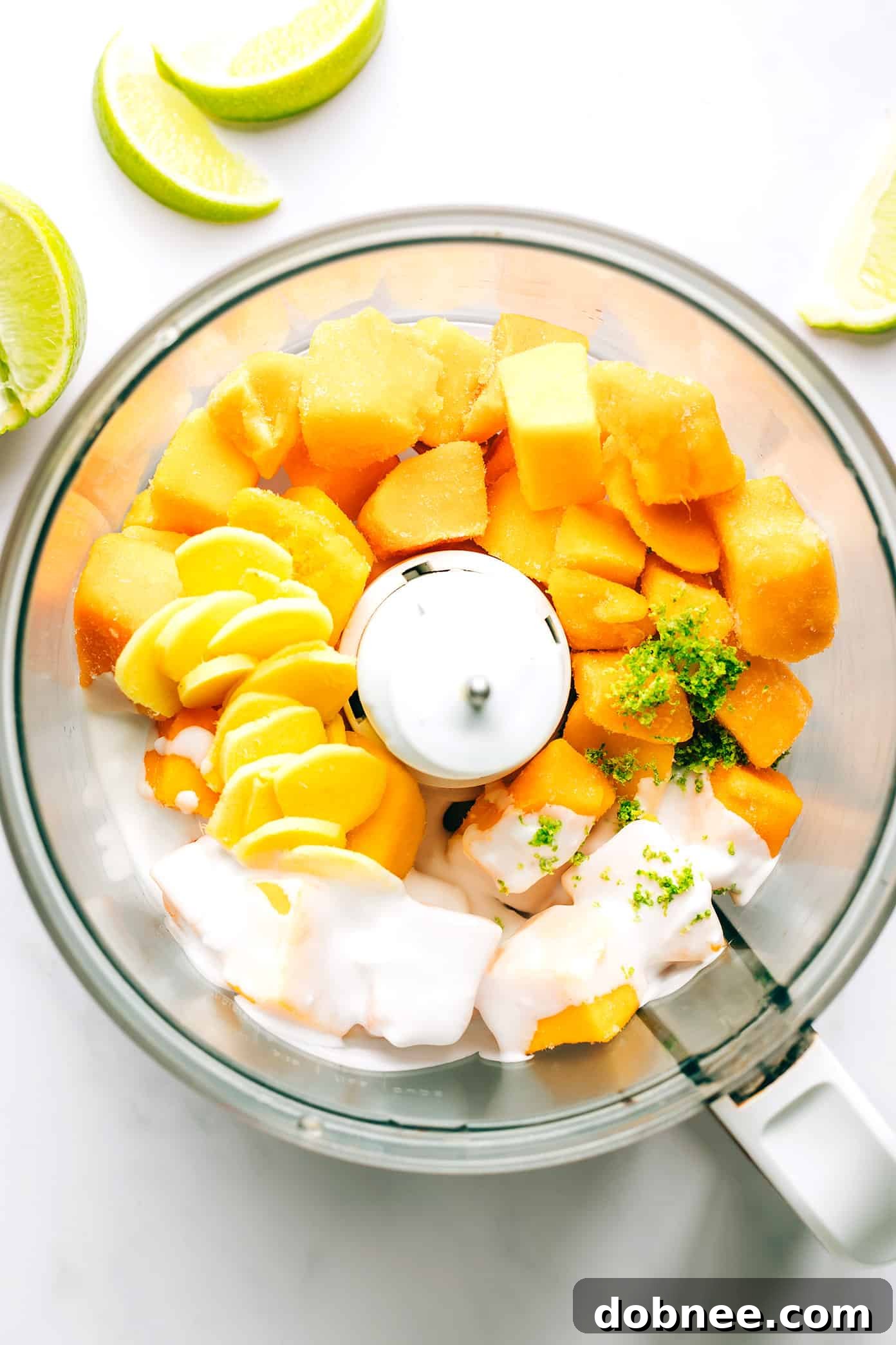 All ingredients for Mango Lime Sorbet placed inside a food processor, ready for blending