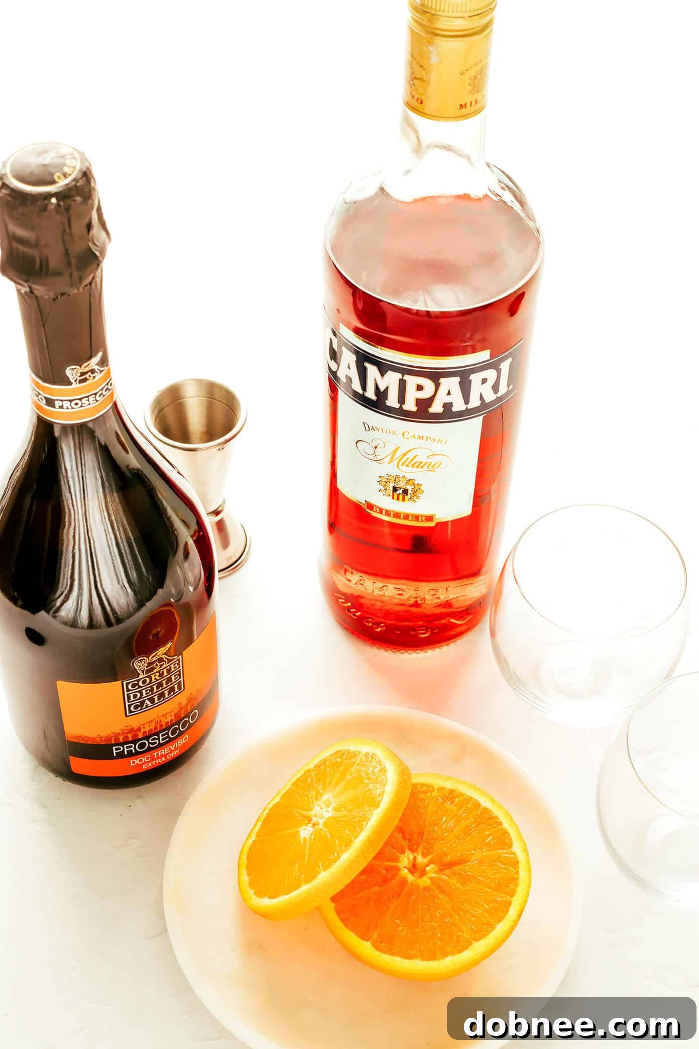 Close-up shot of the vibrant red Campari liqueur being poured into a glass filled with ice, highlighting its rich color.