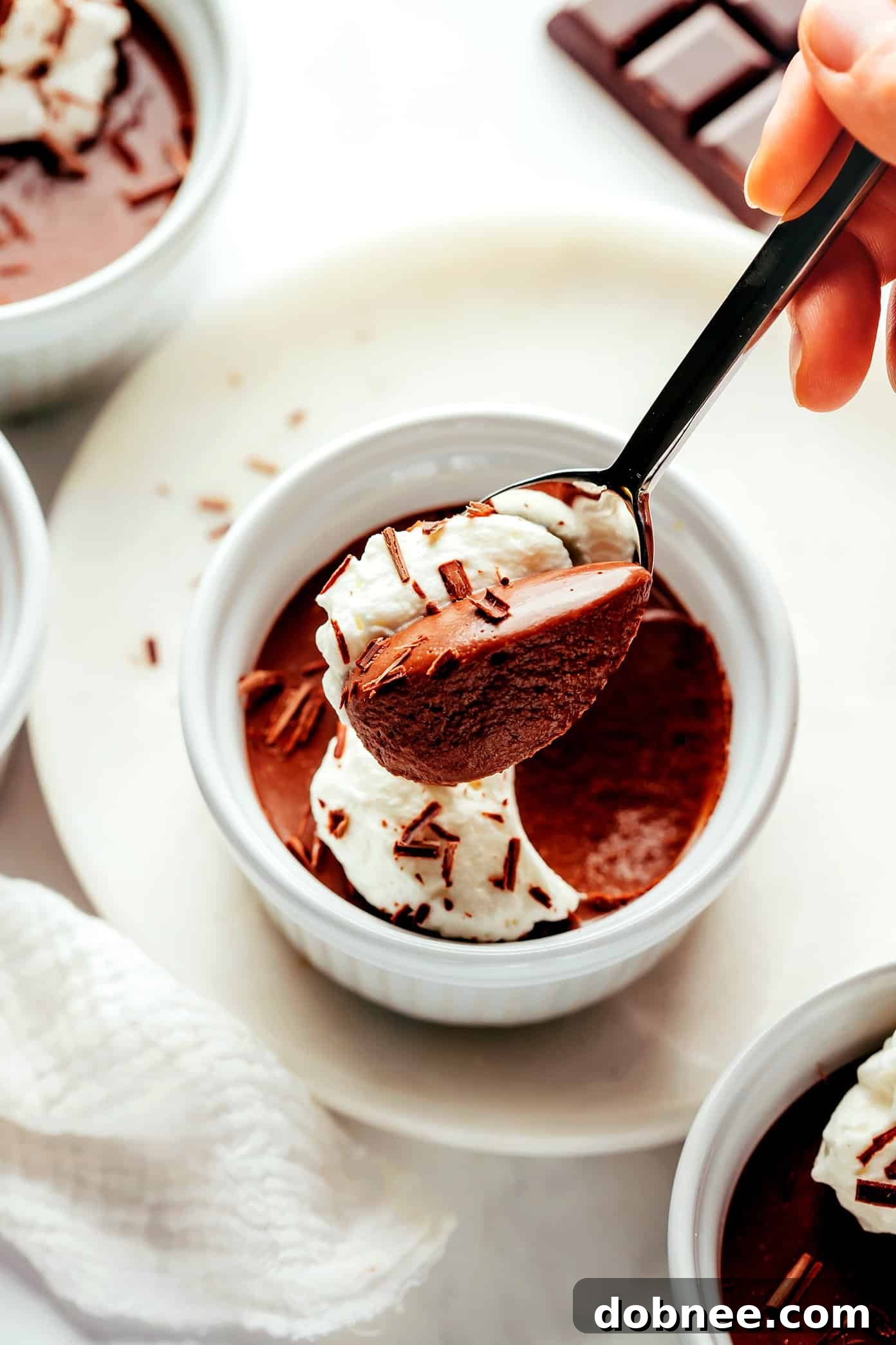 Effortless Silky Chocolate Pots 7 Chocolate pot de crème served in a ramekin with a spoon, showing its creamy texture and rich color.