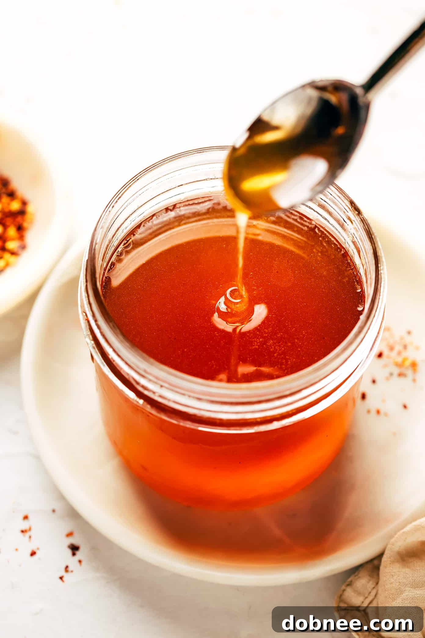 This homemade hot honey recipe is quick and easy to make with 3 ingredients and tastes delicious drizzled on everything from pizza to biscuits, fried chicken, salmon, veggies, baked brie and more! | gimmesomeoven.com Homemade Hot Honey - Sweet and Spicy Condiment
